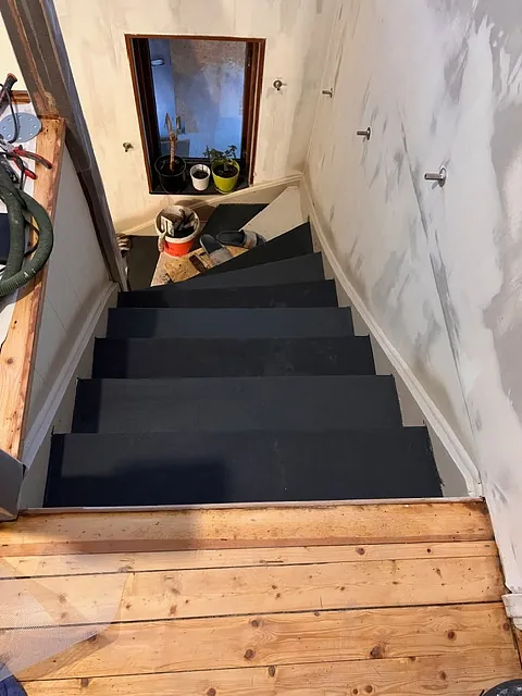 Trappa med mörk täckning och trästeg