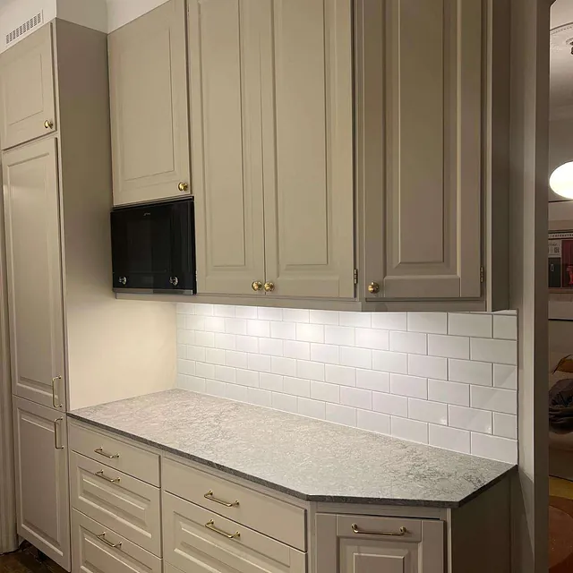 Kök med beige luckor och bänkskiva