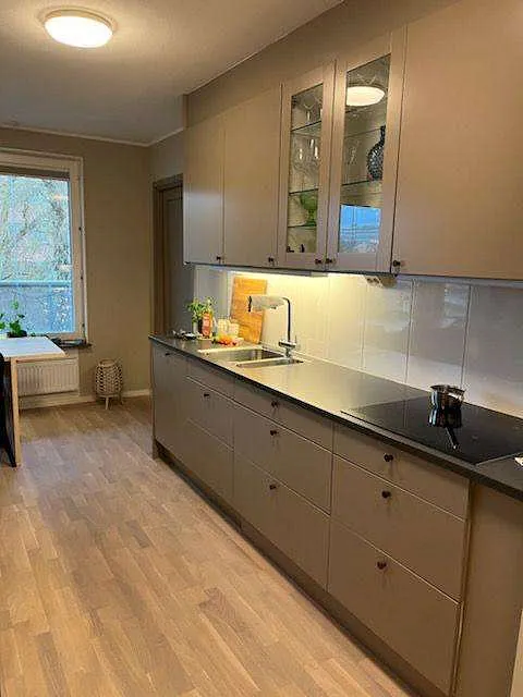 Kök med beige luckor och träbänkskiva